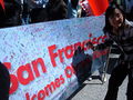 A woman poses with a signed banner welcoming the torch to San Francisco