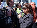 A reporter for 7x7 San Francisco magazine gives a report near Justin Herman Plaza