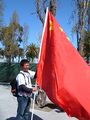 A pro-China protester holding a large national banner on an open side